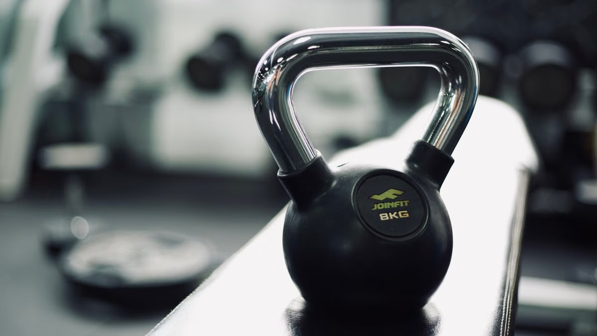 Black kettlebell on gym bench highlighting fitness and strength training equipment.